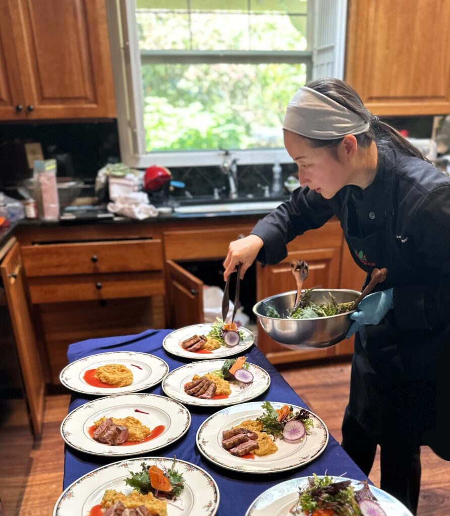 chef mia plating seared duck breast, truffled root mash, seasonal salad